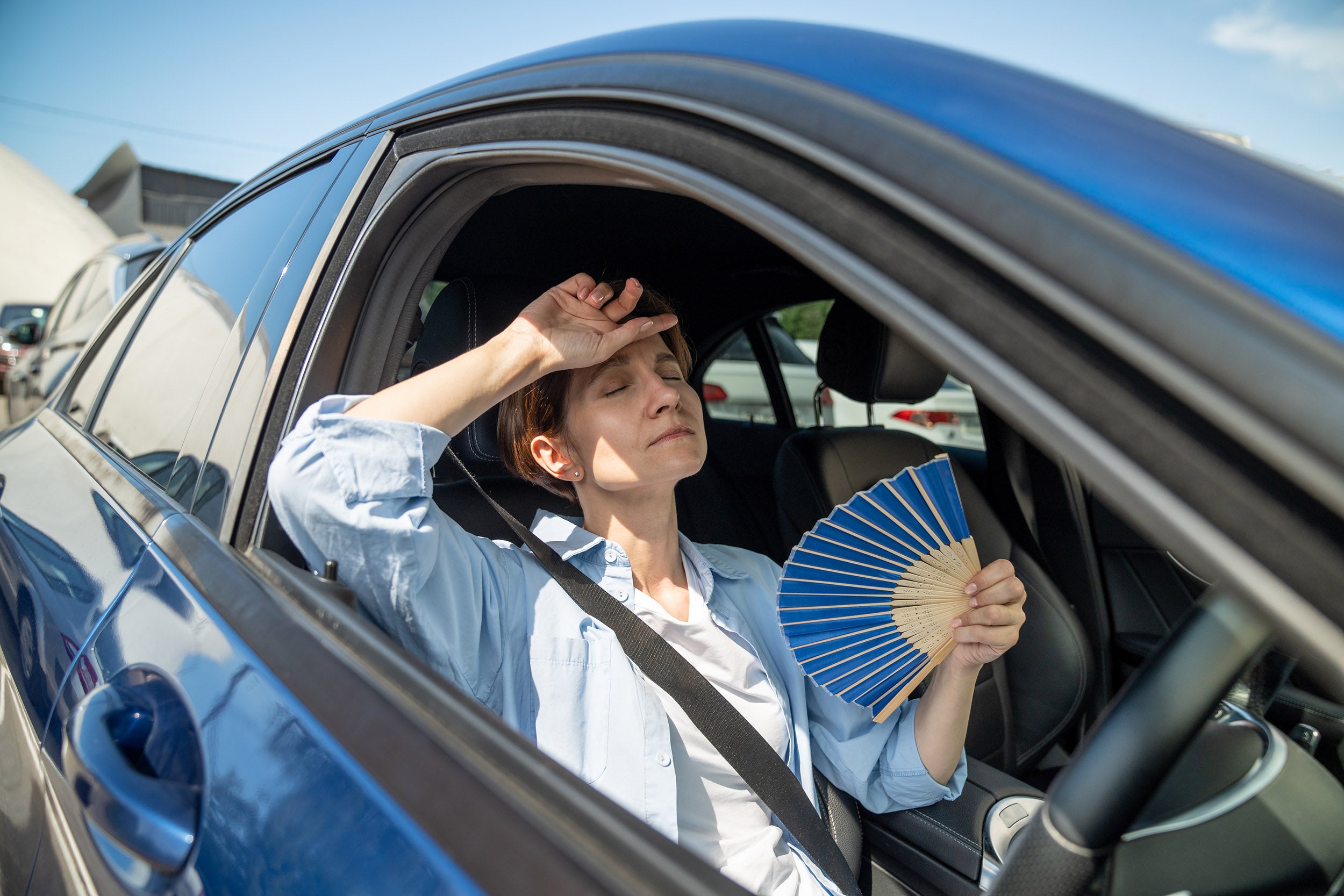 Woman fans herself in a hot car